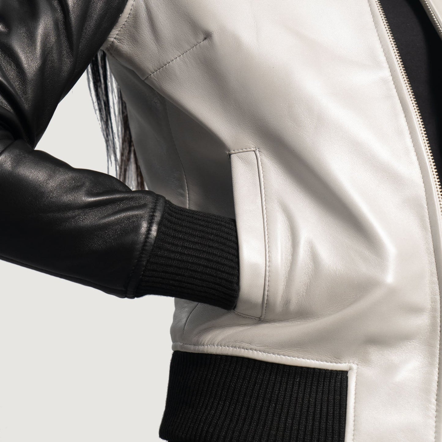 Detail shot of the black knit rib varsity collar and heavy-duty front zipper closure on the silver leather jacket.