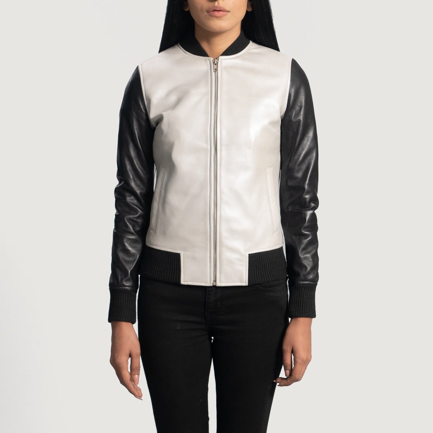 Front view of the Cole silver leather bomber jacket featuring black knit rib varsity collar, cuffs, and hem against a moody workshop background.