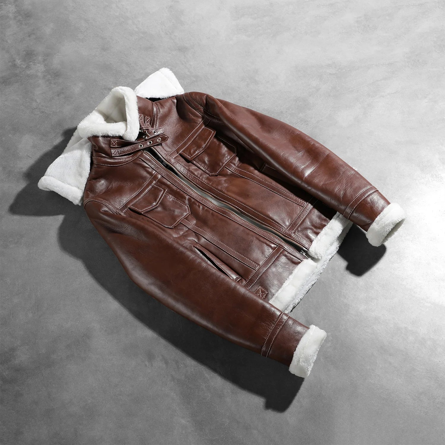 Close up of the four exterior pockets on the front of the brown leather jacket.