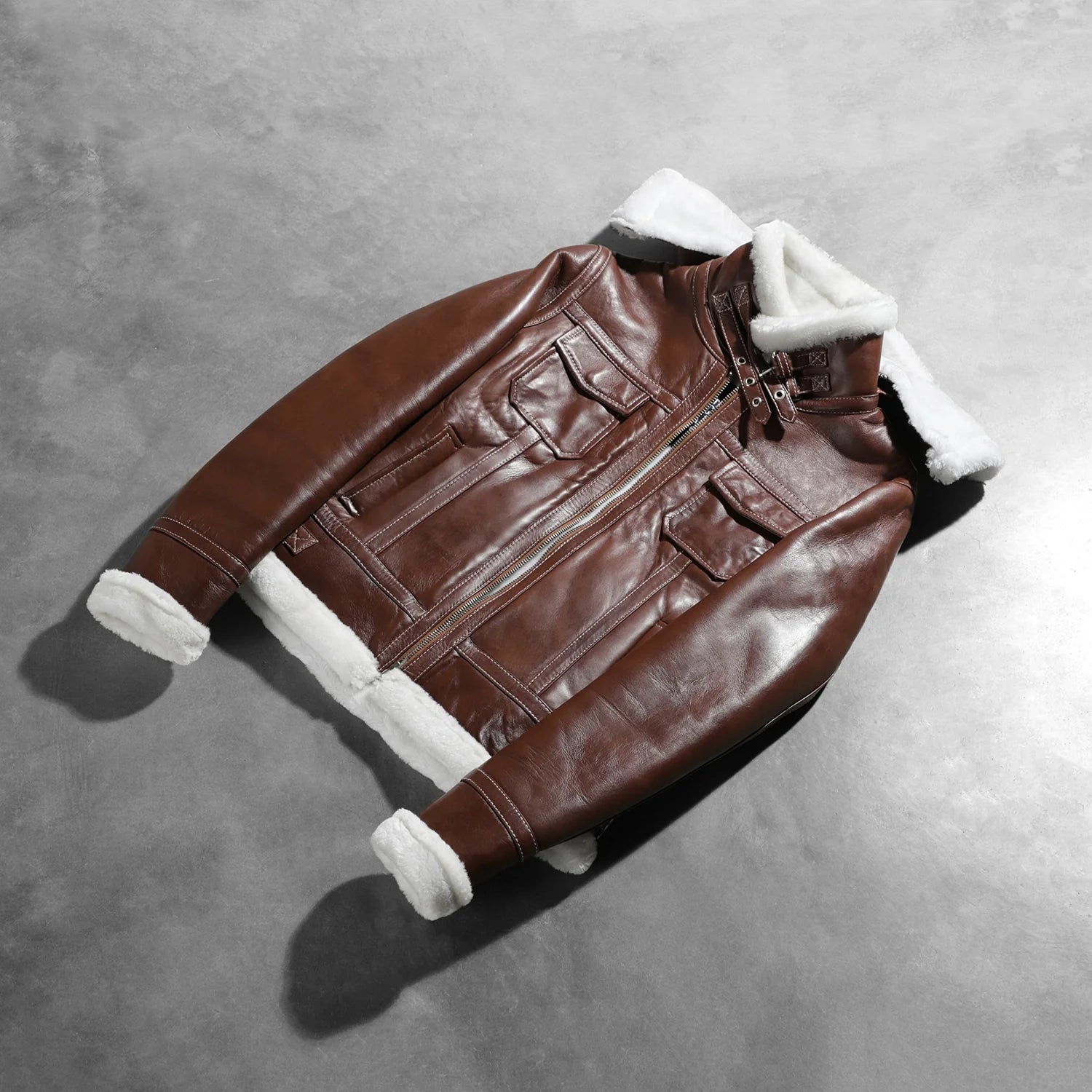 Detail of the open hem sleeve cuffs on the brown hooded leather jacket.