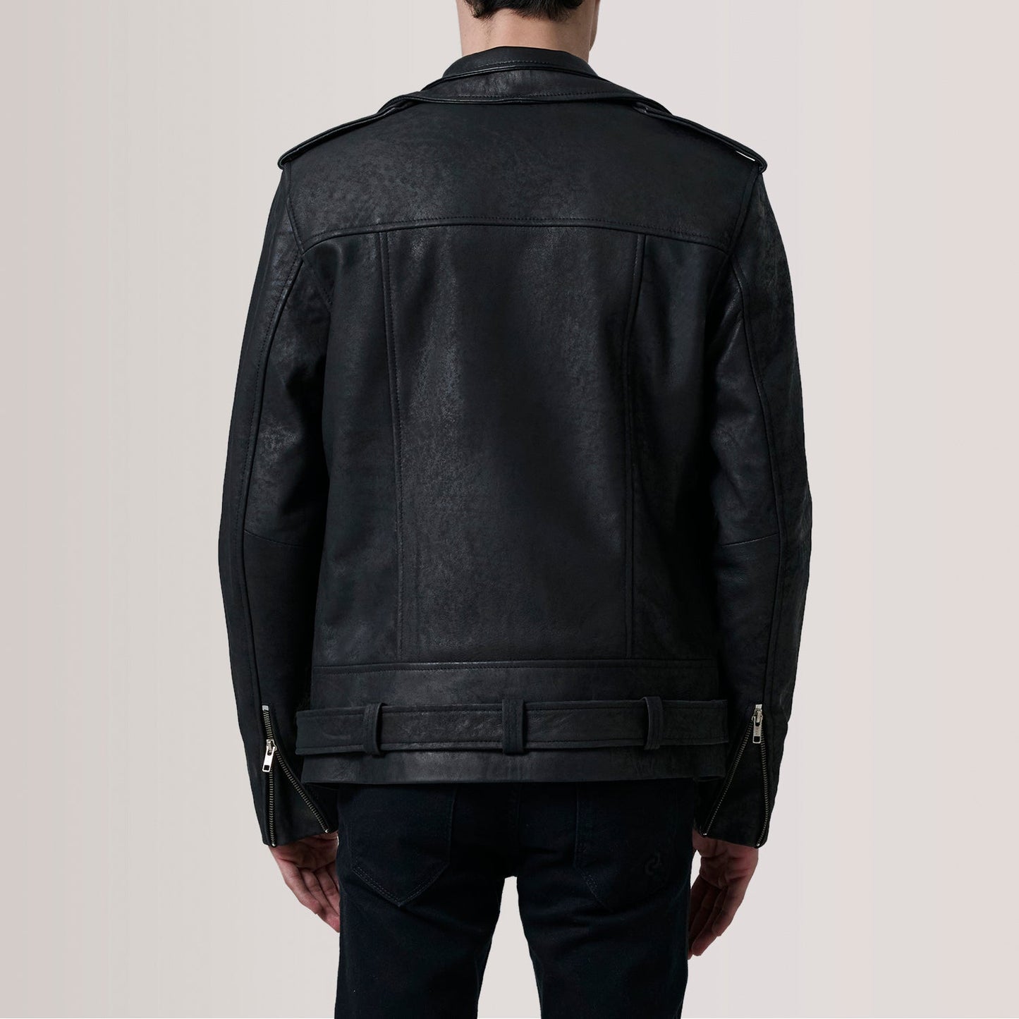 Black leather jacket worn by a person on a plain background