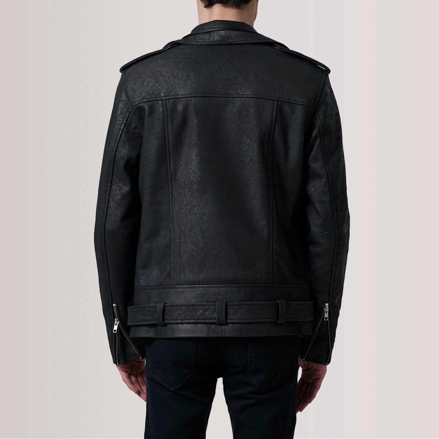 Black leather jacket worn by a person on a plain background