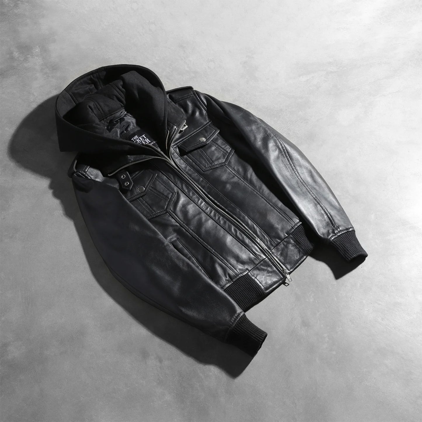Detailed view of the snug rib knit cuffs and the dual chest and waist utility pockets on the front of the jacket.