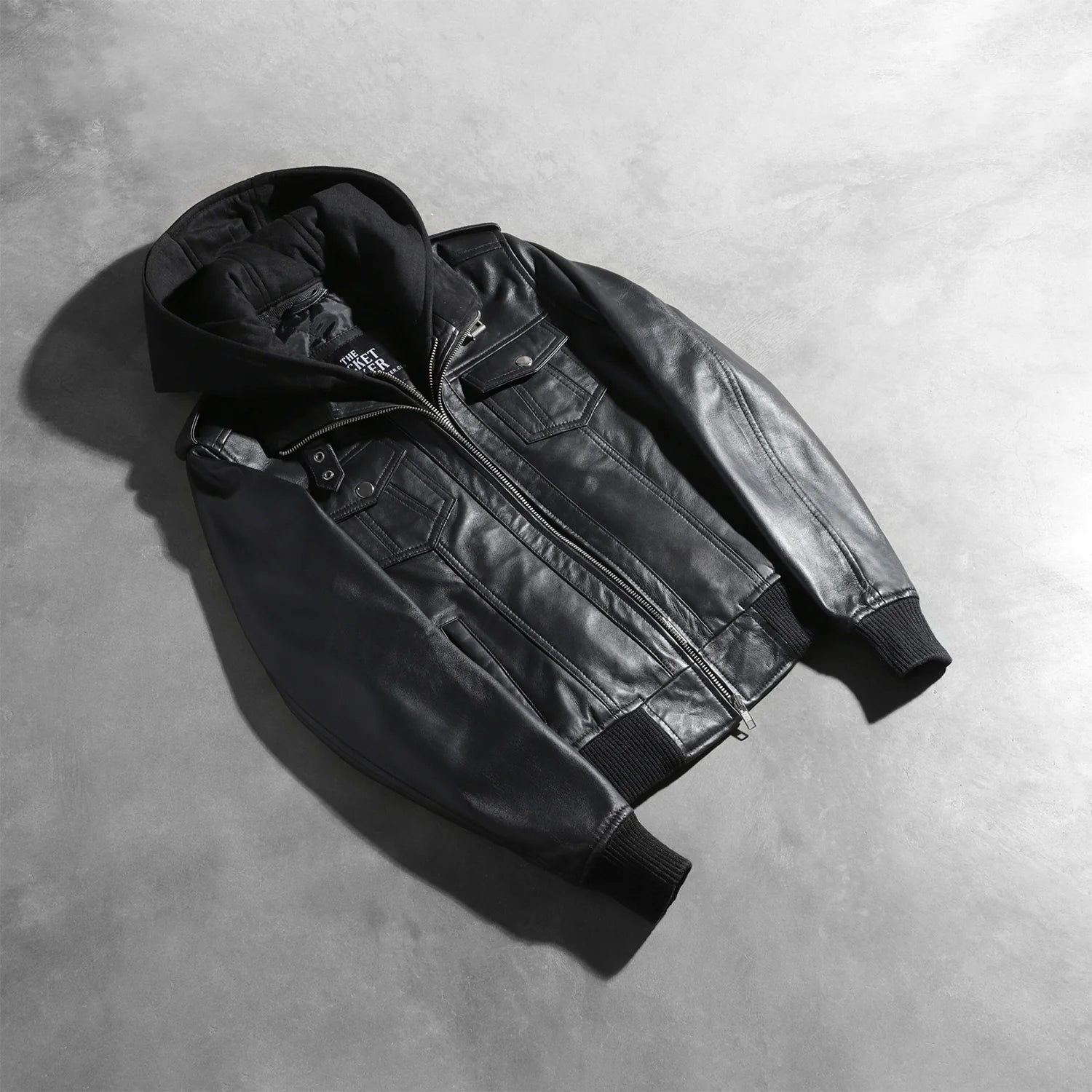 Detailed view of the snug rib knit cuffs and the dual chest and waist utility pockets on the front of the jacket.