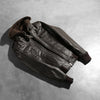 Close up of the high neck collar design with belt buckle detail.