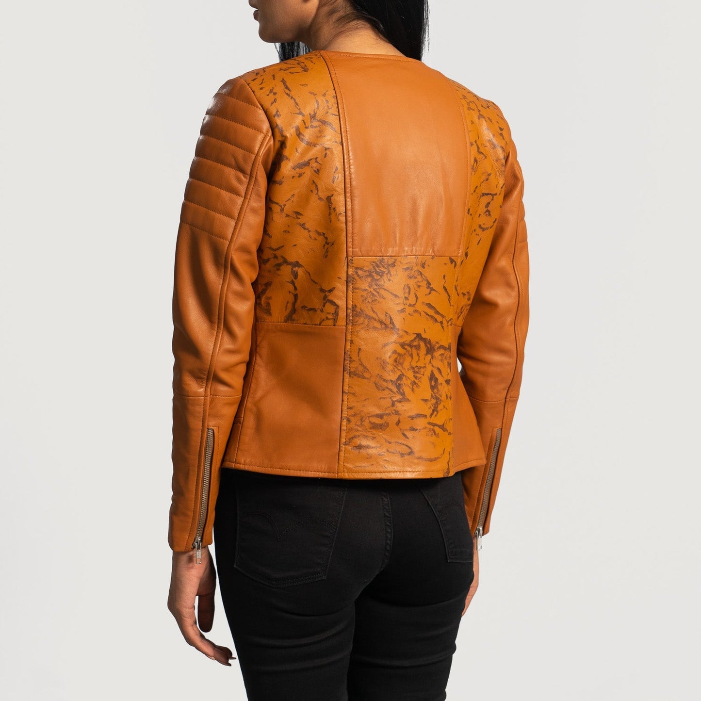Macro view of the sleek collar design on the tan leather jacket.