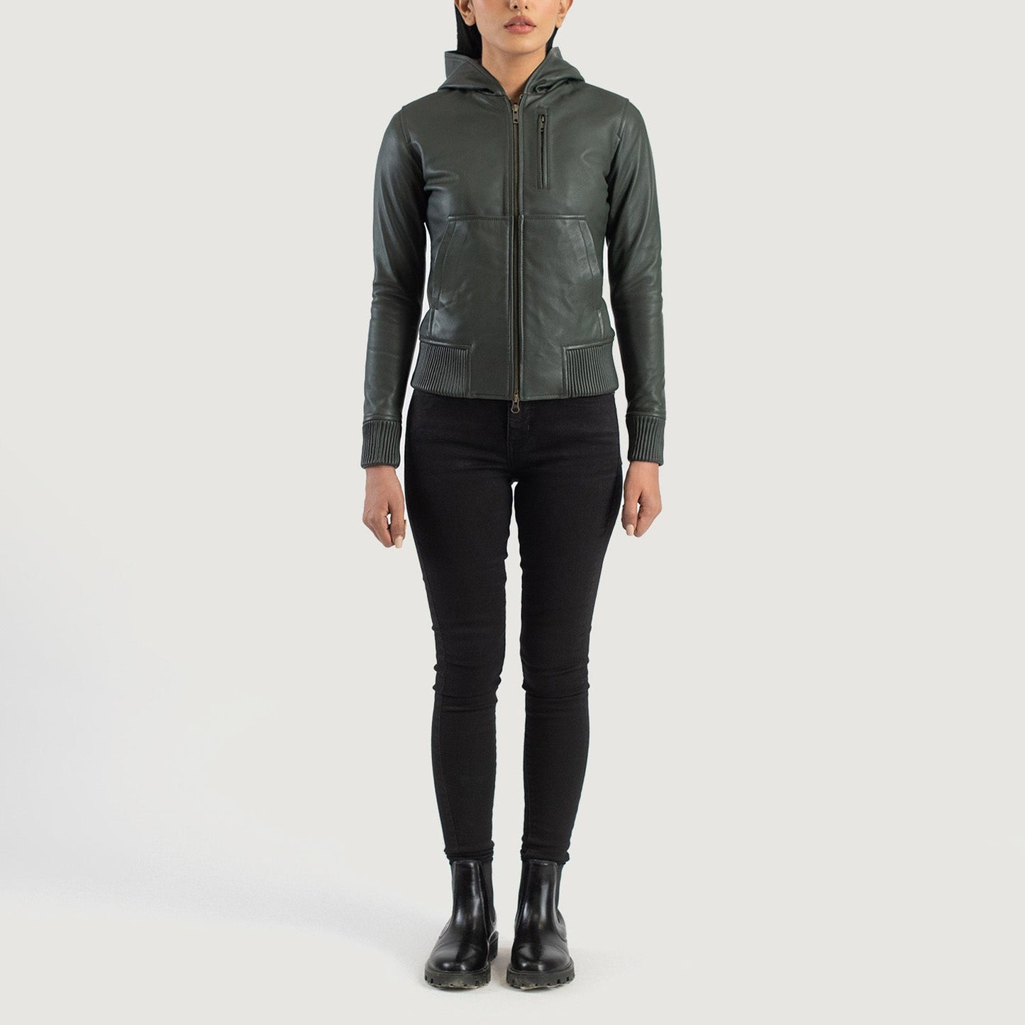 Three-quarter profile view of the green hooded leather jacket, highlighting its relaxed athletic silhouette and comfortable drape.