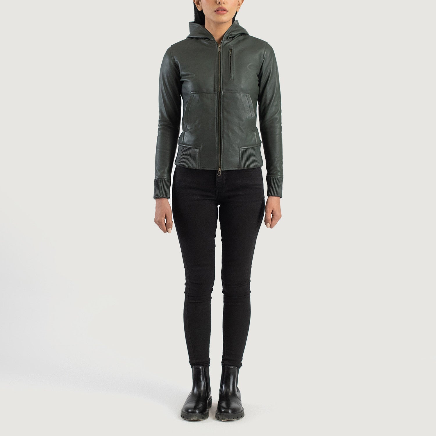 Three-quarter profile view of the green hooded leather jacket, highlighting its relaxed athletic silhouette and comfortable drape.