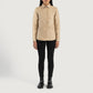 Three quarter profile view of the beige leather shirt jacket, emphasizing its sleek minimalist silhouette and lightweight look.