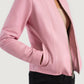 Macro view of the modern collarless neckline design on the pink leather piece.