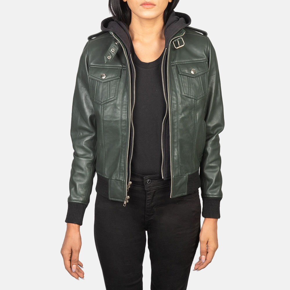 Front view of the green sheepskin leather jacket featuring a high-neck belted collar, shoulder epaulettes, and a removable fabric hood.