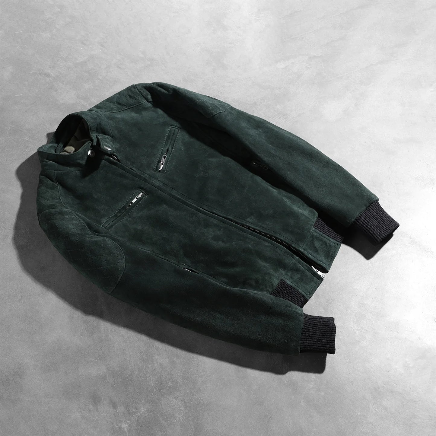 View of the four functional exterior pockets on the green suede bomber.