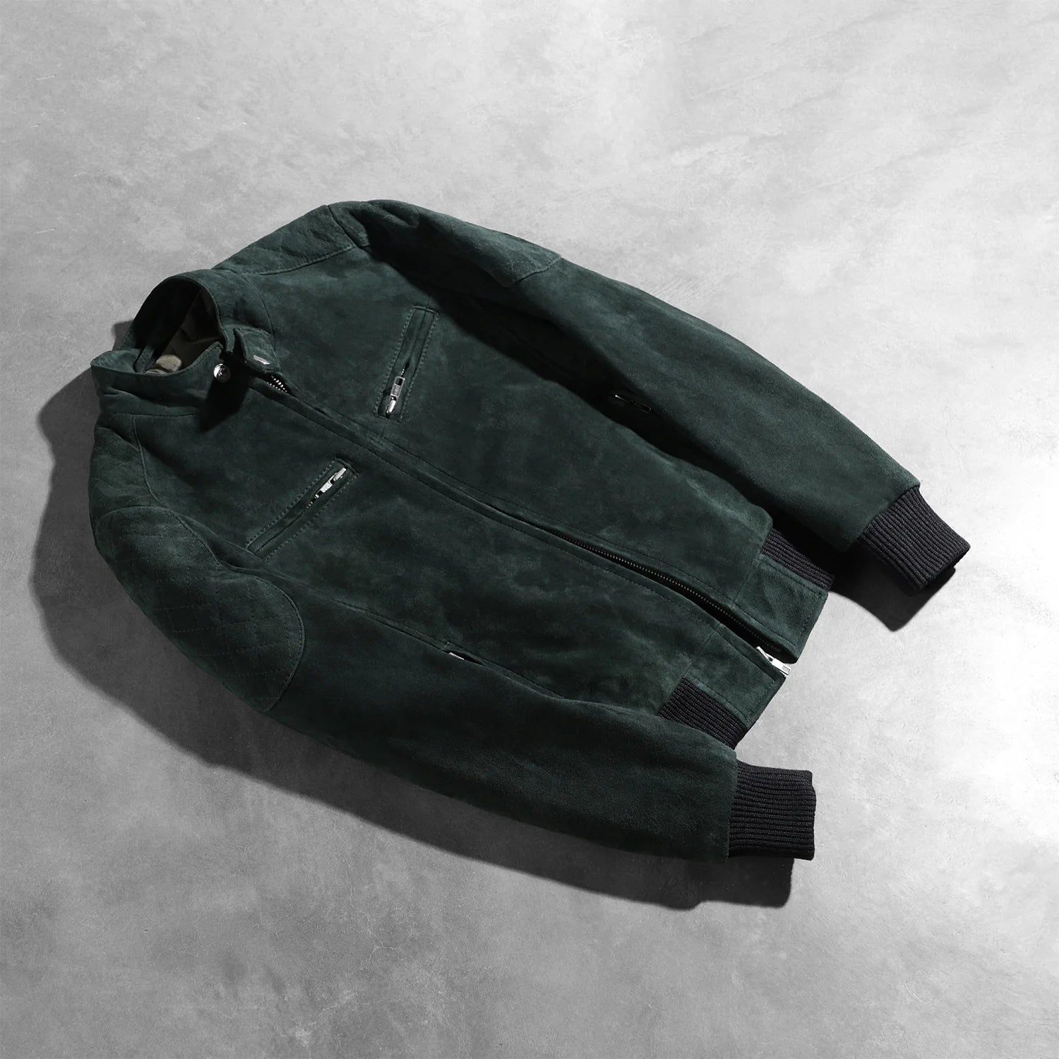 View of the four functional exterior pockets on the green suede bomber.